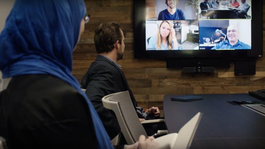 People at conference table video conferencing