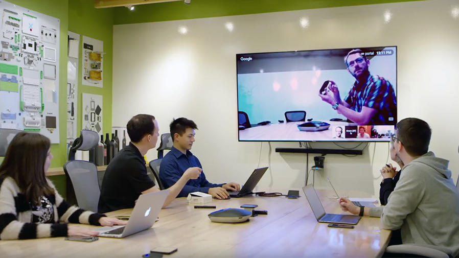 People at conference table video conferencing