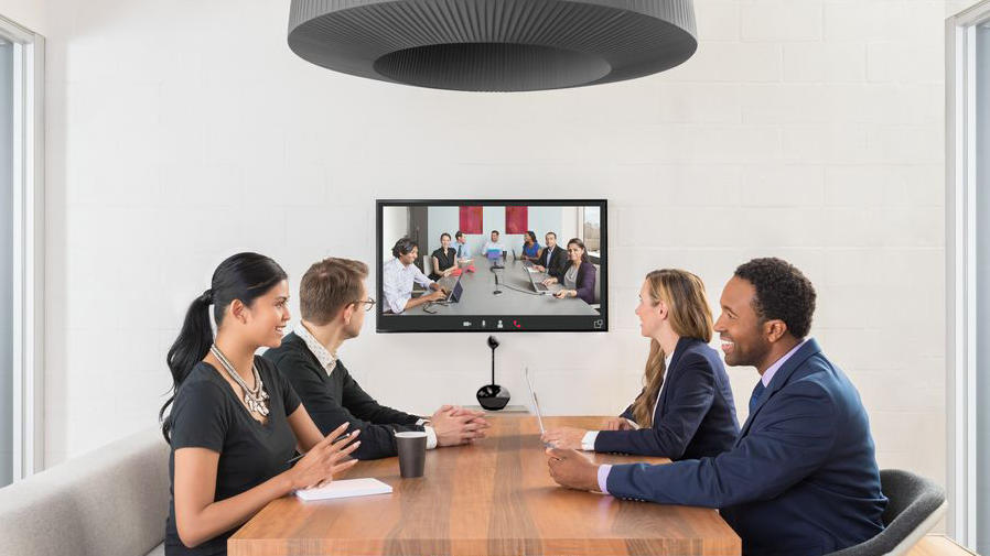 People at conference table video conferencing